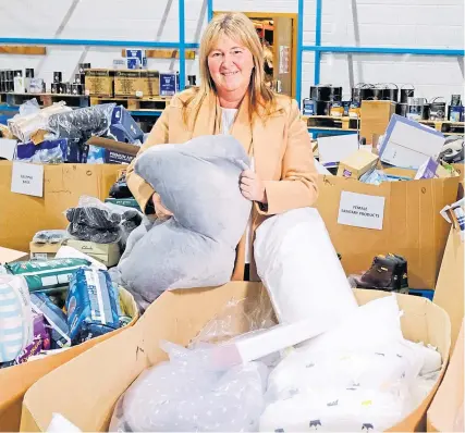  ?? Paul Reid ?? Pauline Buchan, strategic manager of The Cottage Family Centre charity, sifts through items at Amazon’s Lochgelly depot in Fife
Picture