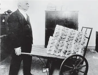  ?? ?? Heavy price: Hyper inflation saw wheelbarro­ws used to carry cash in 1920s Germany