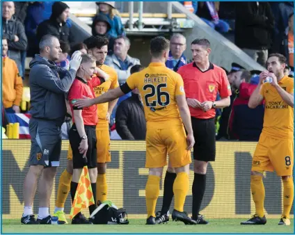  ??  ?? Calum Spence receives treatment after being hit by a coin thrown from the Rangers end.