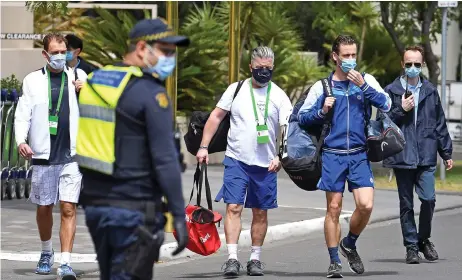  ??  ?? Polish player Lukasz Kubot (left), trainer Hermanus Kroes (centre) and Brazilian player Marcelo Melo (second from right) leave a tennis hotel for a training session in Melbourne on Monday