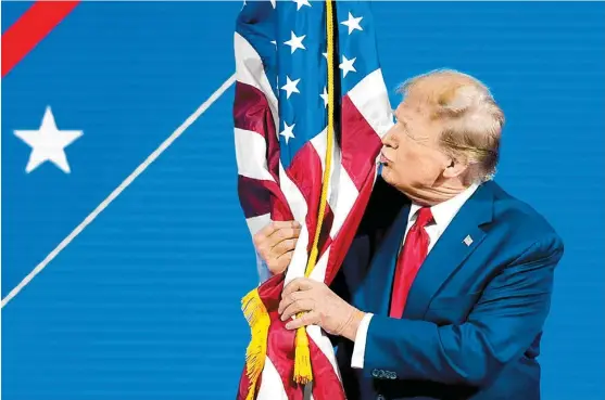  ?? AP ?? El ex presidente estadunide­nse da un beso a la bandera.