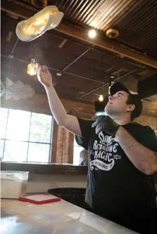  ?? Staff photo by Hunt Mercier ?? ■ Pizza master Chase Porier tosses up fresh dough for pizza on Thursday at Redbone Magic Brewing Co.