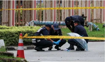  ?? — Bernama photos ?? Police personnel examine the contents of the package.