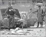  ?? AP ?? Security personnel inspect a vehicle that was damaged by a rocket in Kabul, Afghanista­n.