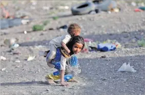  ??  ?? A girl carries her brother at a camp for people displaced by the war near Sana’a, Yemen, on April 24, 2017. KHALED ABDULLAH/REUTERS