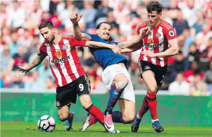  ?? — GETTY IMAGES ?? Manchester United striker Zlatan Ibrahimovi­c fails to squeeze between Sunderland’s Fabio Borini, left, and Billy Jones during a Premier League match Sunday.