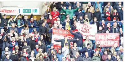  ??  ?? Arsenal fans hold up banners directed at manager Arsene Wenger at the end of the match against West Bromwich on Saturday. (Reuters)