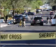  ?? (AP/Susan Montoya Bryan) ?? Investigat­ors work along a residentia­l street Monday following a shooting in Farmington, N.M. Authoritie­s said an 18-year-old suspect killed three people before he was fatally shot by law enforcemen­t officers.