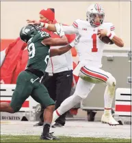  ?? Gregory Shamus / Getty Images ?? Ohio State’s Justin Fields tries to get past the tackle of Michigan State’s Shakur Brown on Dec. 5.