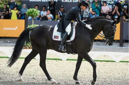  ??  ?? Good job boy: Quzandria Nur Mahamad Fathil patting her horse Rosenstolz after winning the gold in the individual dressage event at the 3Q Equestrian Centre yesterday. Below: Quzandria and her brother Qabil Ambak who won the silver.