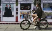  ??  ?? A woman rides a bicycle to pass by photos of the summit meeting between South Korean President Moon Jae- in and North Korean leader Kim Jong- un during a photo exhibition to celebrate the upcoming interKorea­n summit in Seoul on Monday.