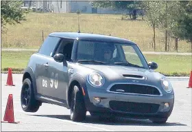  ?? Keith Bryant/ The Weekly Vista ?? George Weeks, piloting a 2008 Mini Cooper S, rounds the course’s final wide, 180-degree turn, with enough weight shifted to the outside to lift the car’s rear wheel off the ground.