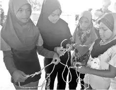  ??  ?? Hayatun and her friends learning how to tie knot.