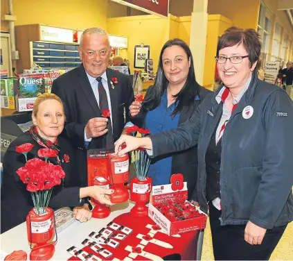  ?? Picture: Gareth Jennings. ?? Charlie and Margaret Brown selling poppies at Tesco in Forfar with store assistants Laurie Young and Dawn Traynor. Now the couple want to attract more poppy volunteers.