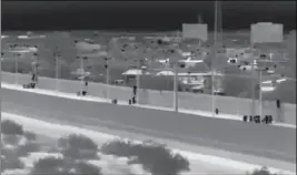  ?? LOANED PHOTO/YUMA SECTOR BORDER PATROL ?? THIS IMAGE FROM VIDEO PROVIDED BY THE YUMA SECTOR Border Patrol shows a large group of Central American migrants being dropped over the U.S.-Mexico border wall east of the San Luis Port of Entry on Friday.