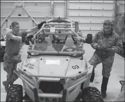  ?? Photos by Peter Loewi ?? TESTING—Captain Danny Hicks of the Air Force Research Laboratory and Tech Sergeant Klosterman of the 123rd Contingenc­y Response Group of the Kentucky Air National Guard pose next to their MRZR before Hicks tests a body heat sensor outside.