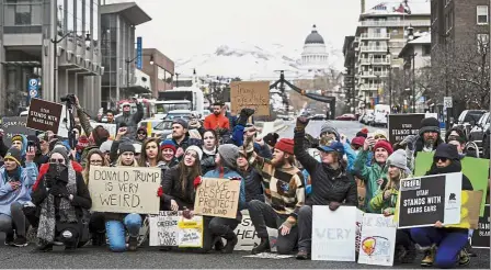  ?? — AP ?? Taking a knee: Protesters kneeling in solidarity against President Donald Trump’s visit to Salt Lake City, Utah.