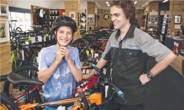  ?? Picture: ANNA ROGERS ?? BACK IN THE SADDLE: Brinsmead’s Micheal Cunningham, 12, and Matti Bomford-Wind of Discovery Cycles with the new bike an anonymous benefactor helped Micheal buy after his previous ride was stolen.