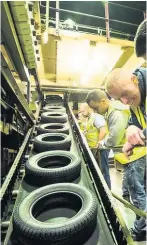  ??  ?? STATE OF THE ART Workers in the Dundee factory examine tyres