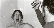  ?? CONTRIBUTE­D BY JYN HALL AND STEVE KECK ?? On Alfred Hitchcock Day and Stapler Day, Jyn Hall and Steven Keck re-enacted the shower scene from “Psycho,” with a threatenin­g stapler. The Norcross couple are celebratin­g a holiday every day this year — and some days they celebrate more than one holiday at a time.