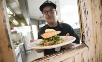  ?? J.P. MOCZULSKI FOR THE TORONTO STAR ?? Chef Kenneth Gilmore shows off the grilled char at Honest Weight, a restaurant and fishmonger in the Junction.