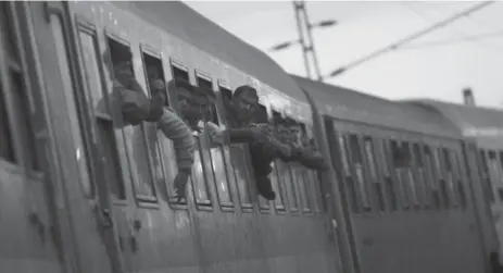  ?? GYORGY VARGA/THE ASSOCIATED PRESS ?? Migrants on a train in Budapest, Hungary. On Friday, the cases of 16 men accused of entering Hungary illegally were tried in a court.