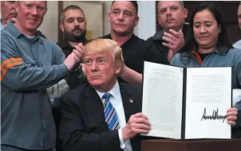  ?? AP PHOTO ?? U.S. President Donald Trump holds up a proclamati­on on steel imports during an event in the Roosevelt Room at the White House in Washington on Thursday. He also signed one for aluminum imports.