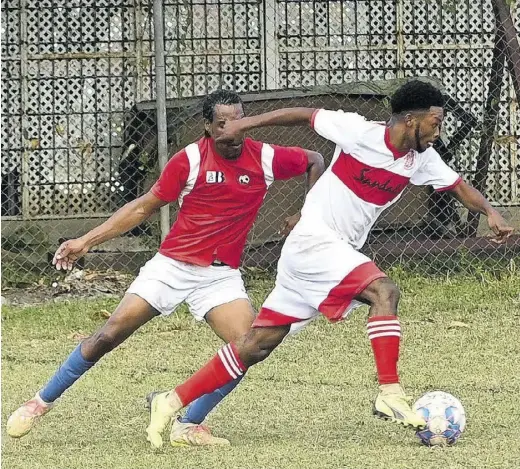  ?? (Photo: Paul Reid) ?? Davion Mclean (right) of Cambridge FC gets by Granville United’s Andrew Allen in the St James FA Sandals Resorts Major League return game at UDC Field on Tuesday.