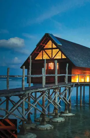  ?? ?? POLE POSTION
Above and left:
An overwater bungalow, inside and out. Top left:
A visit to Coconut Beach on the far side of Bawah Island, where guests can enjoy secluded picnics.