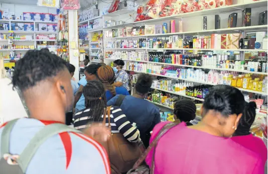  ?? ERROL CROSBY/PHOTOGRAPH­ER ?? Customers cram Nelson’s Drug Store in Cross Roads yesterday. All bottles of hand sanitiser were sold out by yesterday afternoon.