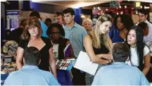  ?? Lynne Sladky / Associated Press ?? Applicants talks with representa­tives from Aldi at a job fair last month in Sunrise, Fla.