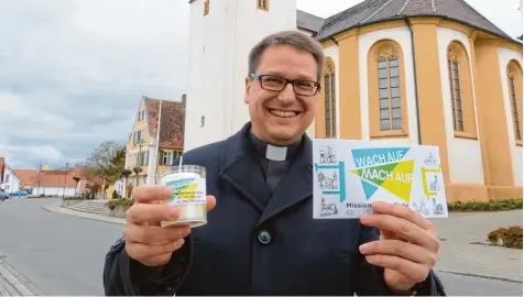  ?? Foto: Hummel ?? Pfarrer Jürgen Eichler mit Kerze und Logo der „Missionari­schen Woche“, die in Wallerstei­n vom Freitag, 3. März, bis Sonntag, 12. März, stattfinde­t.