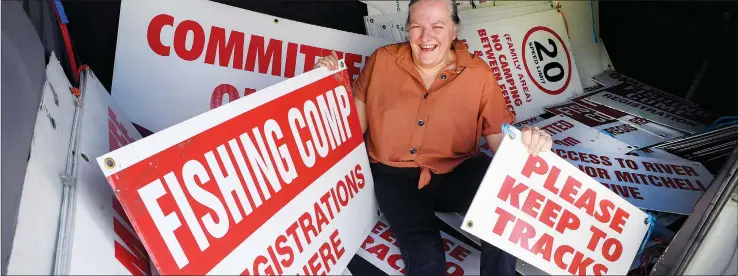  ?? Picture: PAUL CARRACHER ?? DIRECTING TRAFFIC: Participan­ts taking part in The Weekly Advertiser Horsham Fishing Competitio­n on Sunday will find it hard to miss where to go and what to do during the Labour Day weekend event. Competitio­n committee member Prue Beltz is pictured with some of the many signs going up along the Wimmera River to help angling parties make the most of a big weekend. The fishing contest is one of a variety of community events happening across the region. Contest founder reflects, see page 15.