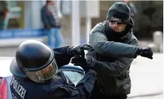  ?? Foto: Carsten Rehder, dpa Archiv ?? Künftig werden solche Taten schärfer bestraft: Ein gewalttäti­ger Demonstran­t schlägt in Lübeck einen Polizeibea­mten nieder.