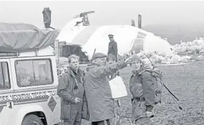  ?? Pictures: PA/Getty. ?? Clockwise from main: Investigat­ors look at what remains of the flight deck of Pan Am 103 in a field near Lockerbie; a policeman stands guard over houses damaged in the crash; convicted Lockerbie bomber Abdelbaset Ali Mohmet al-Megrahi is escorted by security officers; members of a mountain rescue team help in the search around Lockerbie.