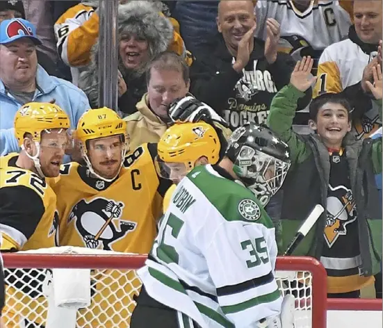  ?? Peter Diana/Post-Gazette photos ?? Sidney Crosby, center, had an immediate impact in his first game back from injury, collecting three points including an assist here on Patric Hornqvist’s second-period goal in the Penguins 5-1 win against the Dallas Stars Wednesday night at PPG Paints Arena.