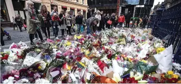 ??  ?? Public show of grief: Hundreds of floral tributes were left at the scene of the bin lorry crash