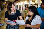  ?? STEVE SCHAEFER / SPECIAL ?? Viviana Cossio (left) talks to a shopper about enrolling in health insurance under the Affordable Care Act on Nov. 3 at Santa Fe Mall in Duluth. Latinos are the least-insured major American ethnic group.