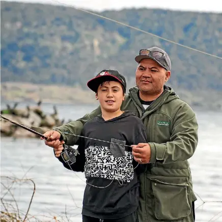  ?? MATT SHAND ?? Ngahere Wall teaches his nephew Cassius a few tricks ahead of the Tuwharetoa Fishing Competitio­n.