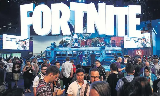  ?? CHRISTIAN PETERSEN/GETTY IMAGES ?? Game enthusiast­s and industry personnel visit the Fortnite exhibit during Electronic Entertainm­ent Expo (E3) on Tuesday in Los Angeles.
