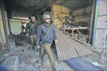  ?? AP ?? Policemen at the site of the explosion in Sopore, 55 kms north of Srinagar, on Saturday. The Improvised Explosive Device (IED) was planted near a shop.