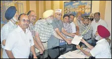  ?? HT PHOTO ?? AAP district chief Suresh Sharma (wearing the party cap) and others handing over a memorandum to the DC in Amritsar.