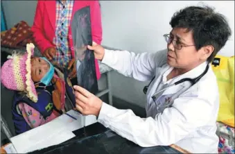  ?? HAO YI / FOR CHINA DAILY ?? A doctor from Beijing looks at a scan of a young patient in Jone county in Gannan Tibet autonomous prefecture, Gansu province, on Monday. About 200 medical experts from the across China visited several counties in the prefecture to provide free...