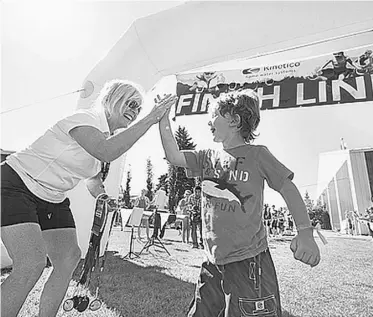  ?? BRAEDEN PETRUK/ FILE ?? Para-athlete Reid Maxwell gets a high-five after last year’s Kinetico Kids of Steel Triathlon.