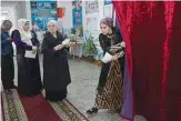  ??  ?? DUSHANBE: A woman leaves a voting booth after casting her ballot for Tajikistan’s parliament­ary election at a polling station in Dushanbe yesterday. —AFP