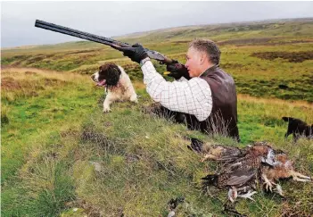  ?? FOTO: DPA ?? Bei der Moorhuhnja­gd in Großbritan­nien gilt das ungeschrie­bene Gesetz, dass die Jagdkleidu­ng strenger riechen sollte als der Jagdhund. Der exklusive „Blutsport“der britischen Oberklasse ist inzwischen aber auch mehr als umstritten.