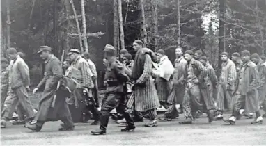  ?? JOURNAL SENTINEL FILES ?? Jack Marcus (shown behind the rifle carried by a German guard) marches along the Noerdliche­n Muenchner street in Gruenwald on a death march from Dachau on April 29, 1945. Marcus survived the Holocaust and died Tuesday in Milwaukee.