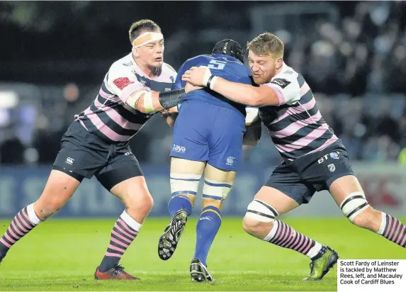  ??  ?? Scott Fardy of Leinster is tackled by Matthew Rees, left, and Macauley Cook of Cardiff Blues