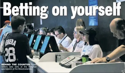  ?? AP ?? BEHIND THE COUNTER: Ticket writers take bets at the FanDuel sportsbook at the Meadowland­s.