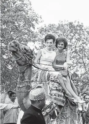  ?? CHRISTIE’S ?? Jacqueline Kennedy, right, and her younger sister, Lee Radziwill, ride a camel during a tour of India and Pakistan in March 1962. The photo is one of the items of jewelry, fine art, books, decorative arts and other memorabili­a up for auction from her home in New York City.